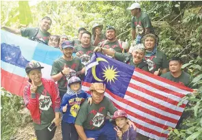  ??  ?? Nik Nazri (fourth right) and Rafie (back row left) with some of the youths holding the Sabah and Malaysia flags after a successful expedition.