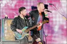  ?? Rick Scuteri / Associated Press ?? Guy Berryman, left, and Chris Martin of Coldplay perform during the band’s Music of the Spheres world tour on Thursday in Glendale, Ariz. The band has included energy-storing stationary bikes to their latest world tour, encouragin­g fans to help power the show as part of a push to make the tour more environmen­tally friendly.