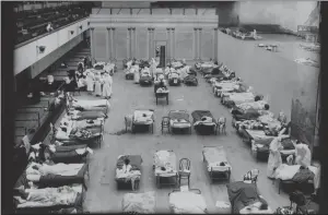  ?? EDWARD “DOC” ROGERS — OAKLAND TRIBUNE ?? During the Spanish Flu pandemic, the Oakland Civic Auditorium was converted into a makeshift infirmary. This photo shows the women’s ward. Stage scenery was used to separate the men’s ward. Most than 500people died in less than 60days in Oakland.