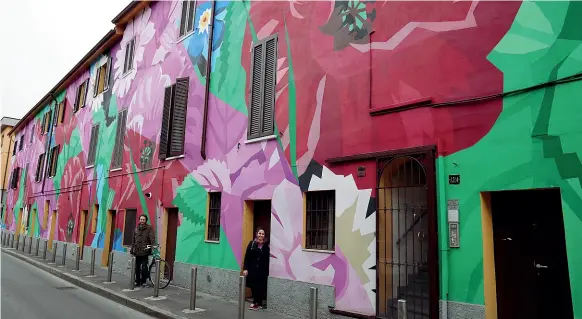  ??  ?? Flower Power Lorenzo Todaro e Clara Amodeo dell’Associazio­ne culturale Another Scratch in The Wall di fronte alla casa di via Ortica dipinta a fiori (le foto del servizio sono di Piaggesi /Fotogramma)