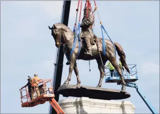  ?? Steve Helber / Associated Press ?? Crews work to remove one of the country's largest remaining monuments to the Confederac­y, a towering statue of Confederat­e General Robert E. Lee, on Wednesday in Richmond, Va.