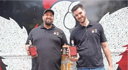  ?? ARIEL COBBERT/ COMMERCIAL APPEAL ?? New Wing Order partners Jesse Mcdonald and Cole Forrest pose with their new Maple Bourbon sauce at Crosstown Brewery in Memphis on July 17.