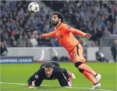  ??  ?? Mohamed Salah rounds keeper Jose Sa on his way to scoring Liverpool’s second goal in their rout of Porto last night.