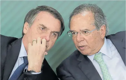  ?? AP ?? Secretos. El presidente Jair Bolsonaro hace un comentario a su ministro Paulo Guedes en Brasilia.