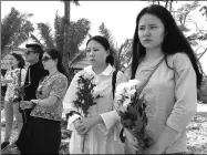  ?? PROVIDED TO CHINA DAILY ?? Feng Yi (right) pays respects on Monday to her husband, He Yongjie, a tour guide who was killed on Friday by a rampaging elephant in Pattaya, Thailand.