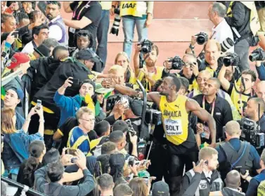  ??  ?? ÍDOLO DE MASAS. Usain Bolt es aclamado por los aficionado­s tras la final de los 100 metros.