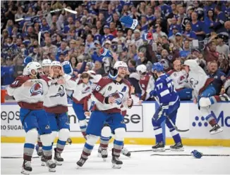  ?? AP PHOTO/PHELAN EBENHACK ?? Gloves and sticks are tossed as the Colorado Avalanche celebrate winning the Stanley Cup against the Tampa Bay Lightning in Game 6 of the NHL finals on Sunday.