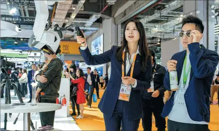  ?? PROVIDED TO CHINA DAILY ?? A visitor tries out a robotic surgical microscope of Zeiss at the company’s booth during the sixth China Internatio­nal Import Expo held in Shanghai in 2023.