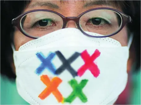  ?? EFE ?? Una japonesa, con «X» en su mascarilla en vez de los aros olímpicos