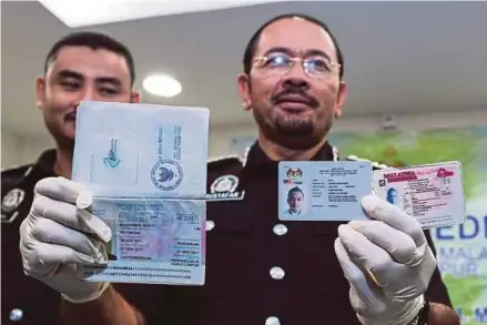  ?? BERNAMA PIC ?? Immigratio­n Department director-general Datuk Seri Mustafar Ali showing the forged documents in Kuala Lumpur yesterday.