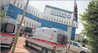  ?? AP PHOTO ?? Ambulances and firefighte­rs gather at the headquarte­rs of the national oil company after an attack by gunmen in Tripoli, Libya, Monday.
