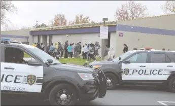  ?? NEWS-SENTINEL PHOTOGRAPH­S BY BEA AHBECK ?? Tokay High School parents line up to check their children out after the school was placed on lockdown after a shooting threat was discovered on a bathroom wall, at the Lodi school Tuesday.