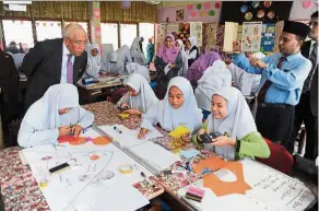  ?? — Bernama ?? Mahdzir (left) has a closer look at students working on an assignment after presenting the IB World School accreditat­ion certificat­e to SMK Sultanah Bahiyah.