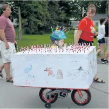  ?? PAT MARCHEN/SPECIAL TO THE EXAMINER ?? Austin Ardiel and his birthday cake on wheels took first prize in his category in the bike decorating contest at the Keene Canada Day parade.