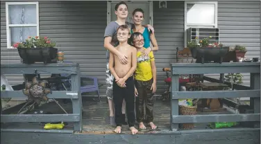  ??  ?? Tasha Lamm, 30, (right) poses for a photo with her girlfriend, Alicia Mullins, 22, and Lamm’s sons, Donovyn, 8, (left) and Gabriel Bonice, 7, in front of their home in Bidwell, Ohio, on July 27. “It sucks being poor,” said Lamm, who is raising her two sons on public assistance. A high-school dropout, she has been promising herself for years she’d get her equivalenc­y degree.