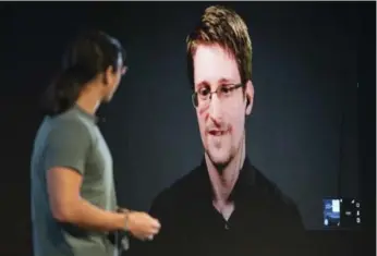  ?? KAYANA SZYMCZAK/NEW YORK TIMES ?? Edward Snowden, appearing via video link at an MIT security conference this month, lives in exile in Russia.