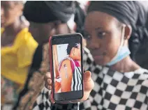  ?? ?? Oumie Nyassi shows a video circulatin­g on the internet and that has been confirmed as fake news of a woman claiming she was magnetized after receiving the COVID-19 vaccine, in a doctors office in Gambia. Nyassi, 24, said that she would get the vaccine only after delivering her baby.