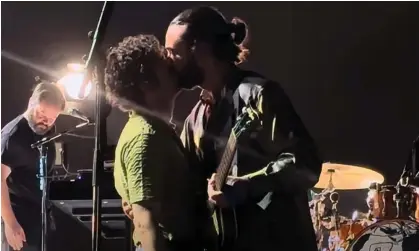  ?? Photograph: Sky News ?? Matty Healy kisses bandmate Ross MacDonald on stage in Kuala Lumpur, Malaysia.