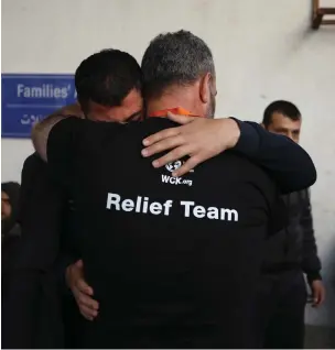  ?? (Ahmad Hasaballah/Getty Images) ?? TWO AID WORKERS comfort each other as they receive the bodies of World Central Kitchen workers who were mistakenly killed by an Israeli air strike in Rafah this week.