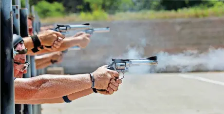  ?? [PHOTOS BY STEVE SISNEY, THE OKLAHOMAN] ?? Competitor­s fire away Friday in the Dale DeBerry Memorial Regional and State Police Pistol Combat Championsh­ips.