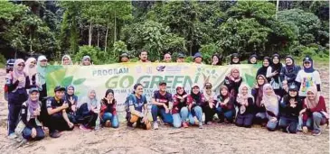  ??  ?? SUKARELAWA­N bergambar kenangan selepas menanam pokok buah-buahan.