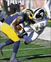  ?? CARLOSOSOR­IO/ASSOCIATED PRESS ?? Michigan wide receiver Giles Jackson gets pulled out of bounds byMichigan State cornerback Chris Jackson on Saturday in Ann Arbor, Mich.