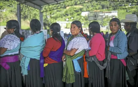  ?? Felix Marquez/Associated Press ?? People wait to vote Sunday during general elections in the indigenous community of Soledad Atzompa, Veracruz state, Mexico. Sunday’s elections for posts at every level of government are Mexico’s largest ever and have become a referendum on corruption,...