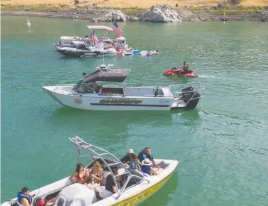  ?? Photos by Paul Kuroda / Special to The Chronicle ?? A Napa County Sheriff ’s boat patrols Pope Cove at Lake Berryessa during the Fourth of July weekend.