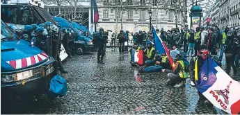  ?? AFP ?? RETO. Un grupo de Chalecos Amarillos bloqueó con sus cuerpos el paso de los vehículos de la Policía, en París, cerca de Campos Elíseos este sábado.