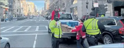  ?? PHOTOS COURTESY SALVATION ARMY OF FITCHBURG ?? Massachuse­tts EDS State Coordinato­r Emily Mew, in truck and also at top, and Eileen Ramsden, from Fitchburg EDS, hand out food, water and more to police officers in Boston on Jan. 20.