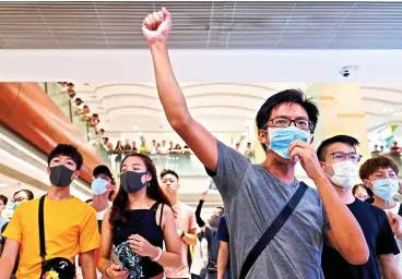  ??  ?? Protesters shout slogans at a shopping mall in Hong Kong on Saturday. Hong Kong authoritie­s were limiting airport transport services and controllin­g access to terminals, as they braced for the second weekend of disruption following overnight demonstrat­ions that turned violent.