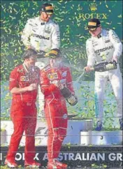  ??  ?? Ferrari's Sebastian Vettel (front right) is sprayed with champagne by Lewis Hamilton (back left), and Valtteri Bottas (right).