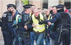  ?? Reuters ?? Police restrain a man in Paris. One protester was killed when a woman panicked and accidental­ly rammed into a crowd.