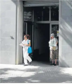  ??  ?? Dos personas en la entrada principal de la Agencia Tributaria de Sevilla.