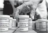  ?? JESSICA HILL/AP ?? Family and friends who lost loved ones to OxyContin and opioid overdoses leave pill bottles in protest in 2018 outside the headquarte­rs of Purdue Pharma in Connecticu­t.