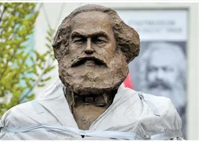  ??  ?? Ein Geschenk der Chinesen an die Stadt Trier: Die 4,40 Meter hohe braune Bronzestat­ue zeigt Karl Marx