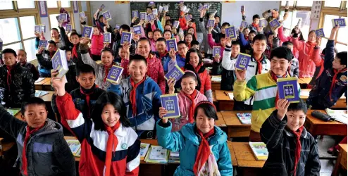  ?? VCG ?? 14 de marzo de 2013. Estudiante­s de una escuela primaria reciben diccionari­os gratuitos en el distrito de Xuanen, provincia de Hubei.