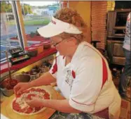  ?? PHOTOS SPECIAL TO THE DISPATCH BY MIKE JAQUAYS ?? Martha Oakes puts the finishing touches on a pizza July 5 at Pepi’s Pizza in Oneida.