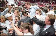  ?? SEAN D. ELLIOT/THE DAY ?? UConn players carry women’s basketball coach Geno Auriemma off the floor after the team cut down the nets to win the program’s first NCAA championsh­ip, April 2, 1995, at the Target Center in Minneapoli­s.