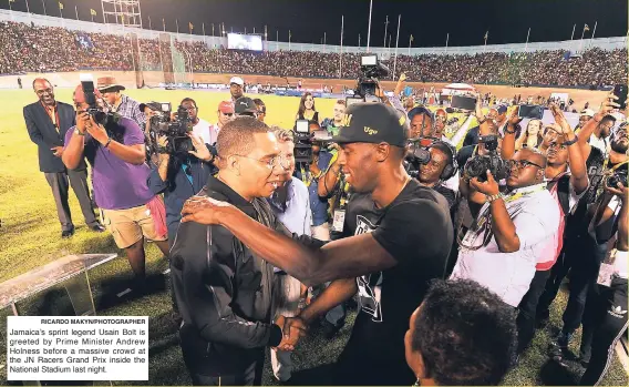  ?? RICARDO MAKYN/PHOTOGRAPH­ER ?? Jamaica’s sprint legend Usain Bolt is greeted by Prime Minister Andrew Holness before a massive crowd at the JN Racers Grand Prix inside the National Stadium last night.