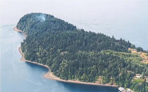  ?? TED S. WARREN/THE ASSOCIATED PRESS ?? Smoke rises from the site on Ketron Island in Washington state where an Horizon Air turboprop plane crashed Friday night after it was stolen from the Seattle airport.