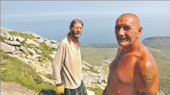  ?? 01B19anvil­02 ?? Davy and Fraser take a breather on their way up Goatfell with the anvil last year.