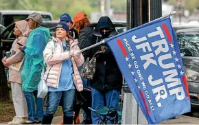  ?? TNS ?? A woman waves a Donald Trump and John F Kennedy Jr flag along Elm St at Dealey Plaza in downtown Dallas.