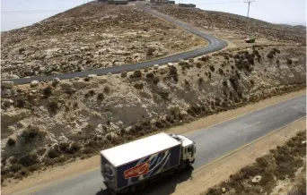  ?? (Reuters) ?? A TRUCK passes a small Israeli community in the West Bank.