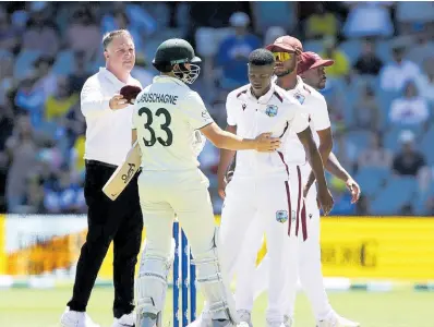  ?? AP ?? Australia’s Marnus Labuschagn­e (second left) consoles West Indies’ Shamar Joseph (centre) after Australia won by 10 wickets on the third day of the first Test match in Adelaide, Australia yesterday.