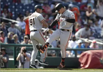  ?? LUIS M. ALVAREZ — THE ASSOCIATED PRESS ?? The Giants' Joc Pederson, right, celebrates with third base coach Mark Hallberg during the seventh inning after hitting his second home run of the game in Sunday's 12-3victory over the host Washington Nationals.