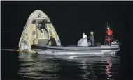  ?? BILL INGALLS/NASA VIA AP ?? Support teams work around the SpaceX Crew Dragon Resilience spacecraft shortly after it landed Sunday with NASA astronauts Mike Hopkins, Shannon Walker, and Victor Glover, and Japan Aerospace Exploratio­n Agency (JAXA) astronaut Soichi Noguchi aboard in the Gulf of Mexico off the coast of Panama City, Florida.