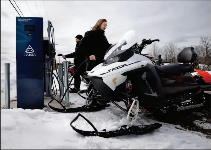  ?? NASUNA STUART-ULIN / THE NEW YORK TIMES ?? Battery-powered snowmobile­s produced by Taiga Motors are charged March 29 at a port in Saint-paulin, Quebec, Canada. While electric cars get most of the attention, electric lawn mowers, boats, bicycles, scooters and all-terrain vehicles are proliferat­ing.