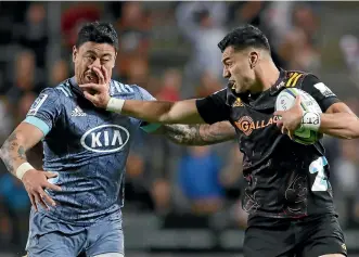  ?? GETTY IMAGES ?? Shaun Stephenson of the Chiefs tries to fend off Hurricanes wing Ben Lam during a typically bruising Super Rugby derby in Hamilton in February.