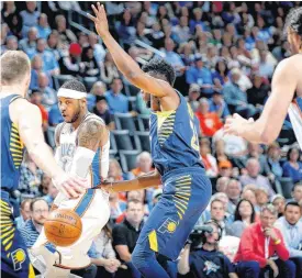  ?? [PHOTO BY BRYAN TERRY, THE OKLAHOMAN] ?? Oklahoma City’s Carmelo Anthony passes the ball between Indiana’s Domantas Sabonis and Thaddeus Young during Wednesday’s game between the Oklahoma City Thunder and the Indiana Pacers.